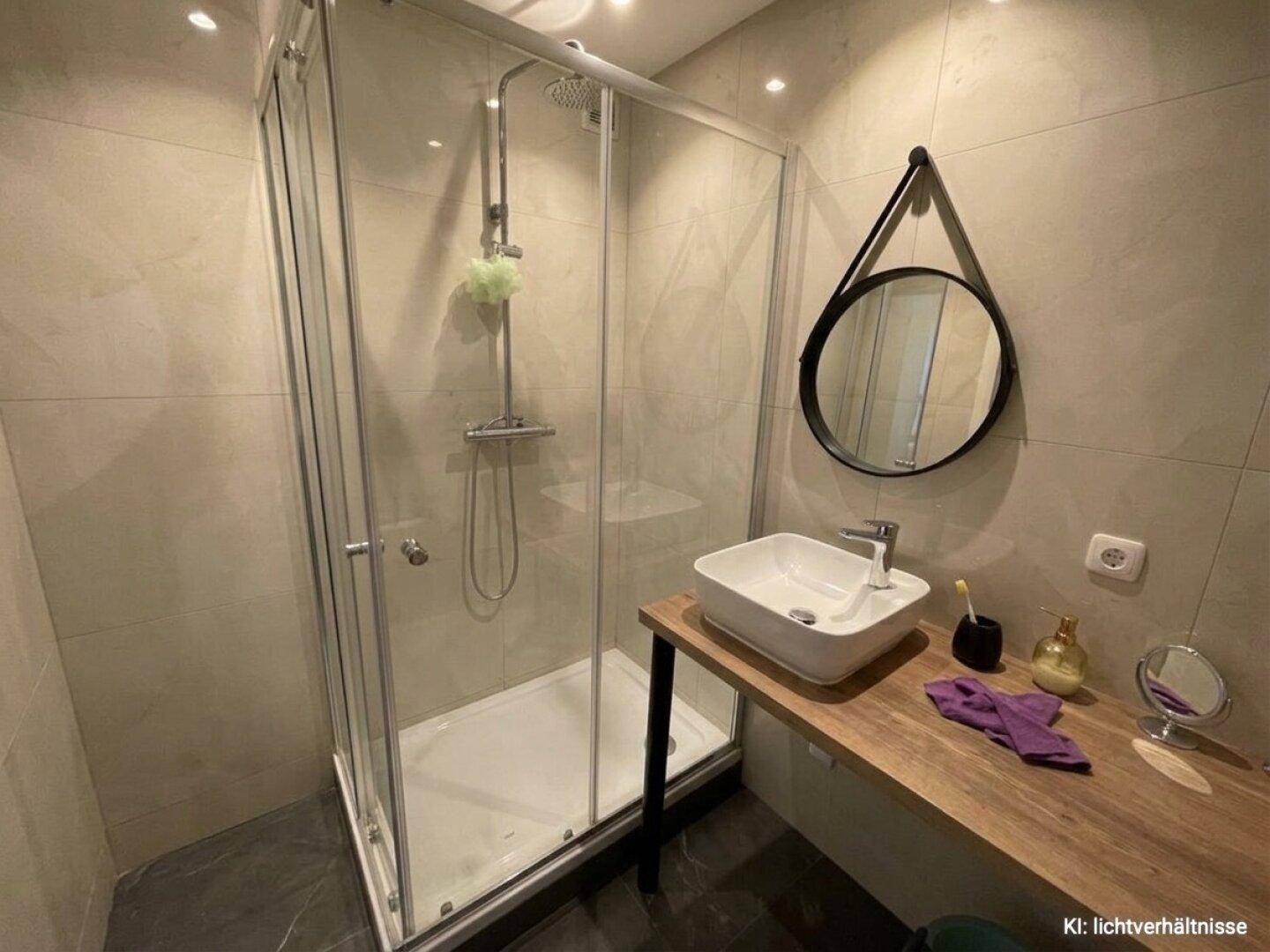 Modernes Badezimmer mit ebenerdiger Dusche und stilvollem Waschbecken auf Holzplatte.