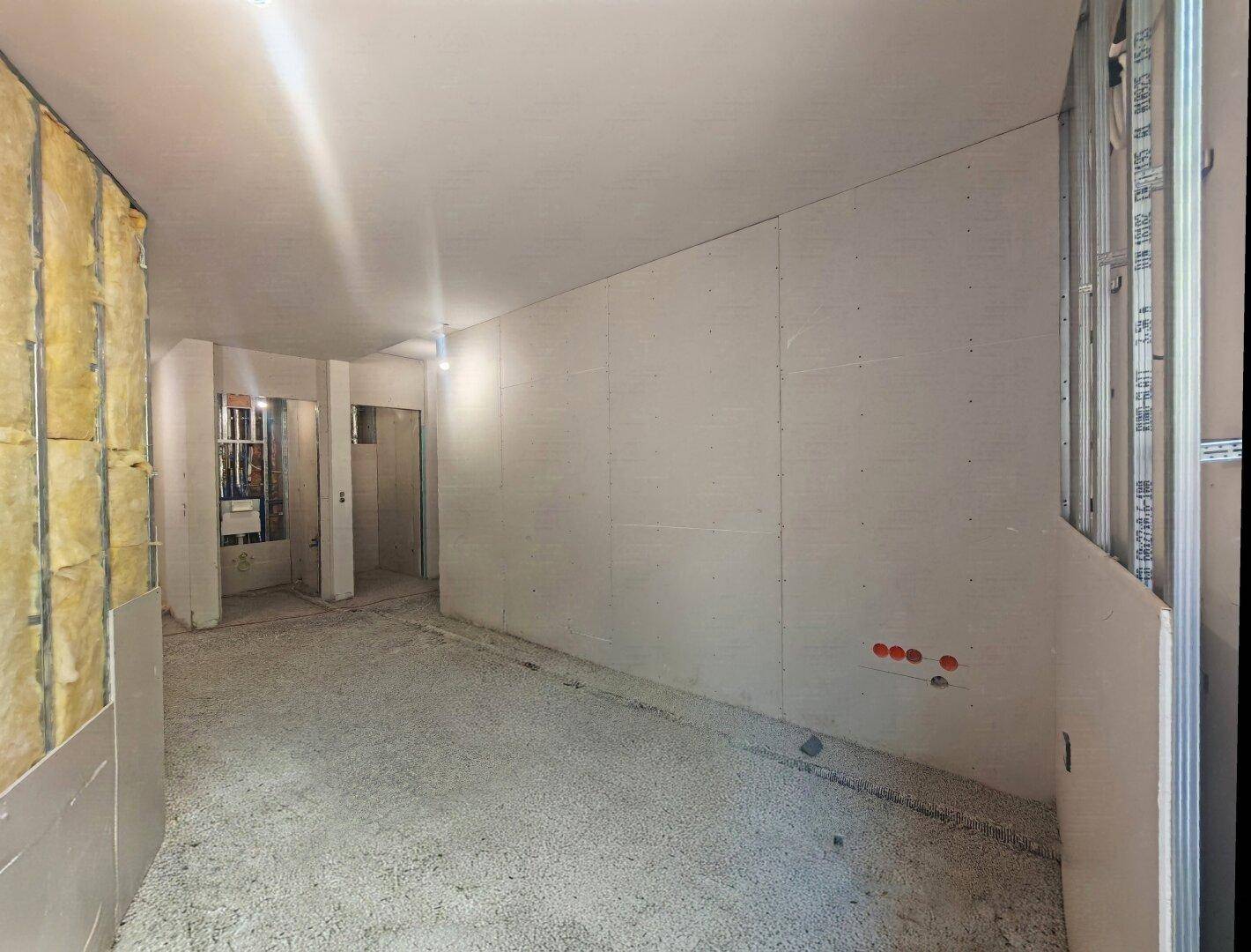 Innenraum im Rohbau mit Dämmung und verkleideten Wänden, bereit für die weitere Gestaltung.