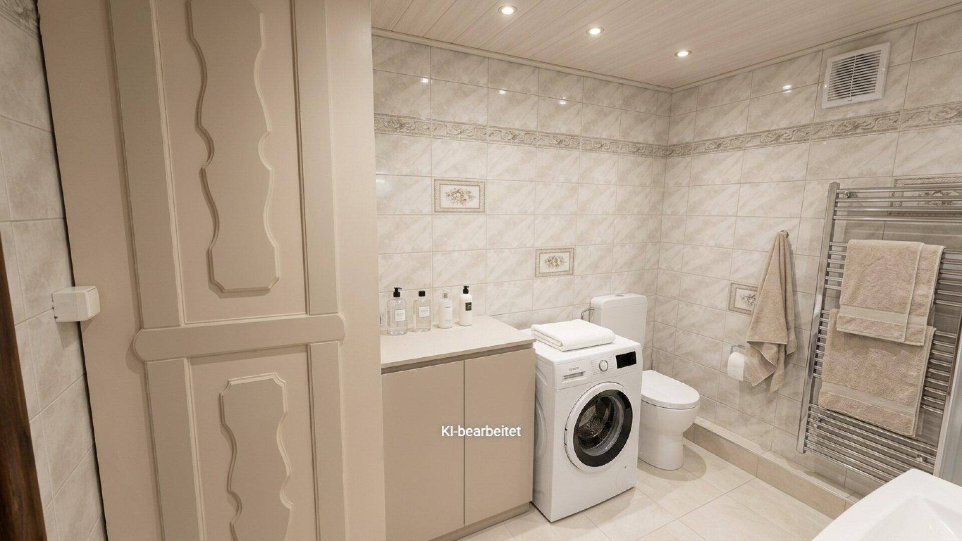 Modernes Badezimmer mit Waschmaschine, WC, Waschtisch und beheiztem Handtuchhalter.