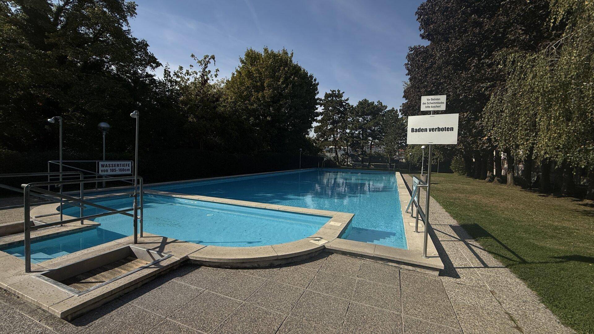 Großes Freibad mit klarem Wasser und umliegender Grünfläche, ideal für den Sommer.