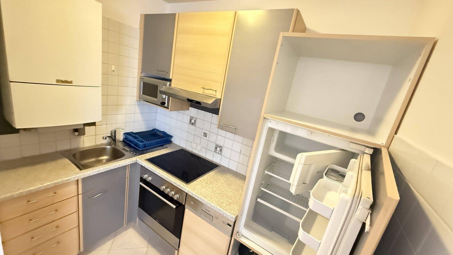 Gut ausgestattete Küche mit Kühlschrank, Kochfeld und Backofen, ideal für den täglichen Gebrauch.