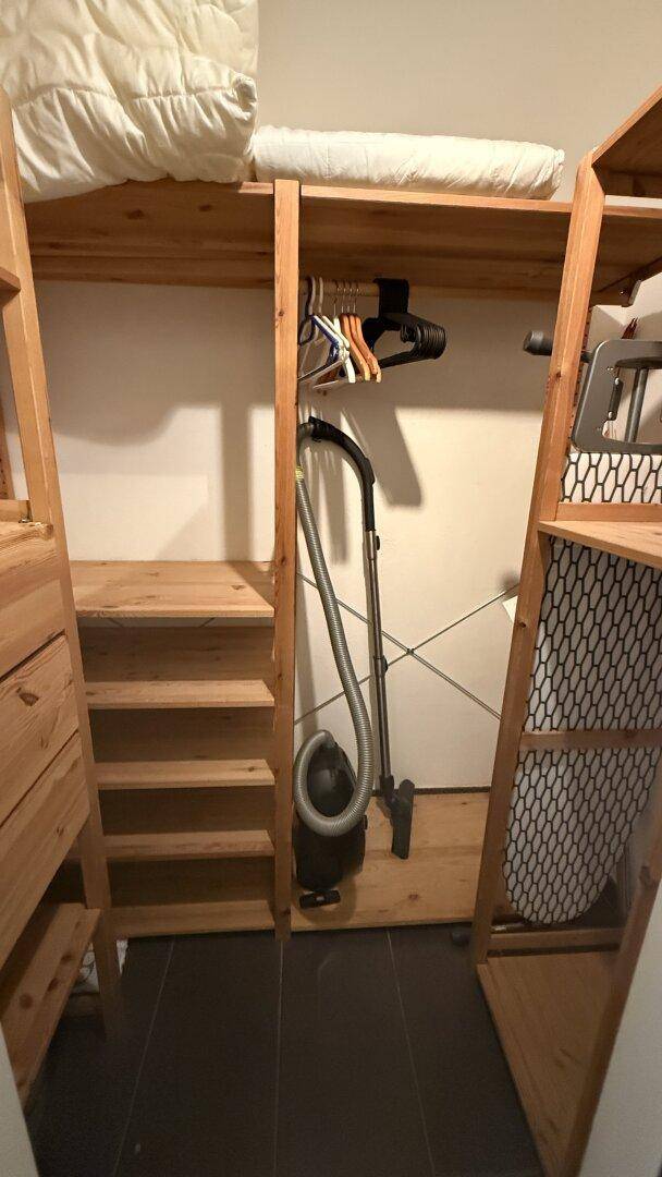 Praktischer Stauraum mit Regalen und Platz für Haushaltsgeräte wie einen Staubsauger.