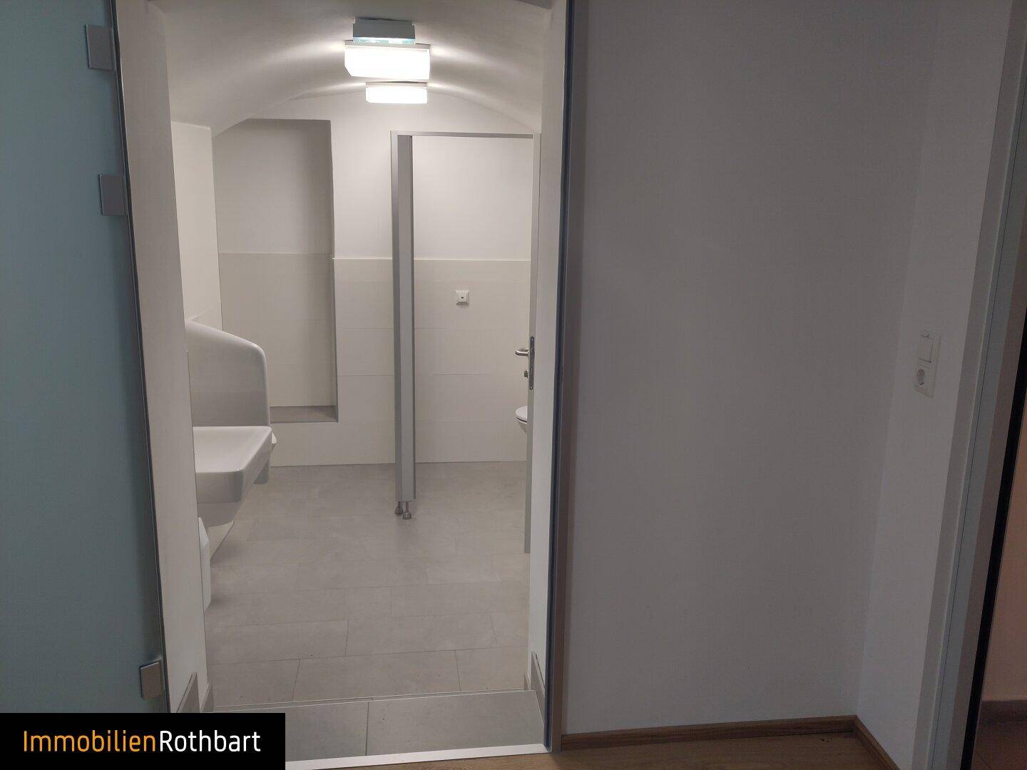 Sauberer Sanitärbereich mit Urinalen und Toilettenkabinen, hell beleuchtet.