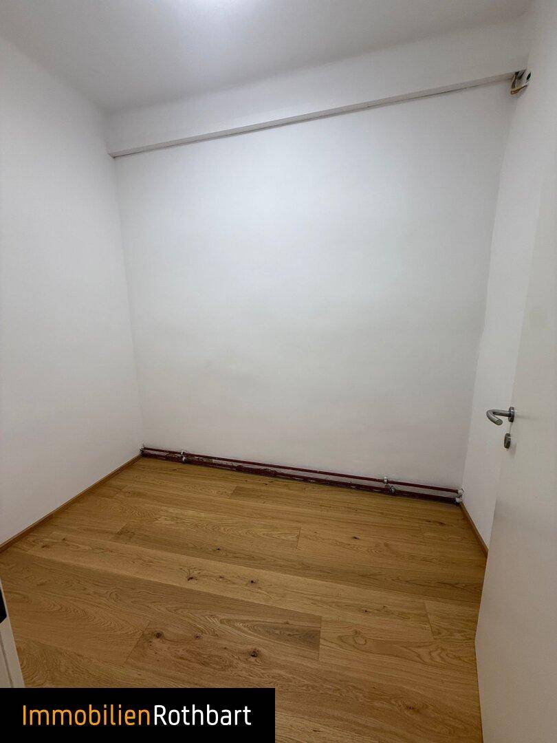 Kleiner, leerer Raum mit Holzboden und weißen Wänden, geeignet als Abstellraum oder Büro.