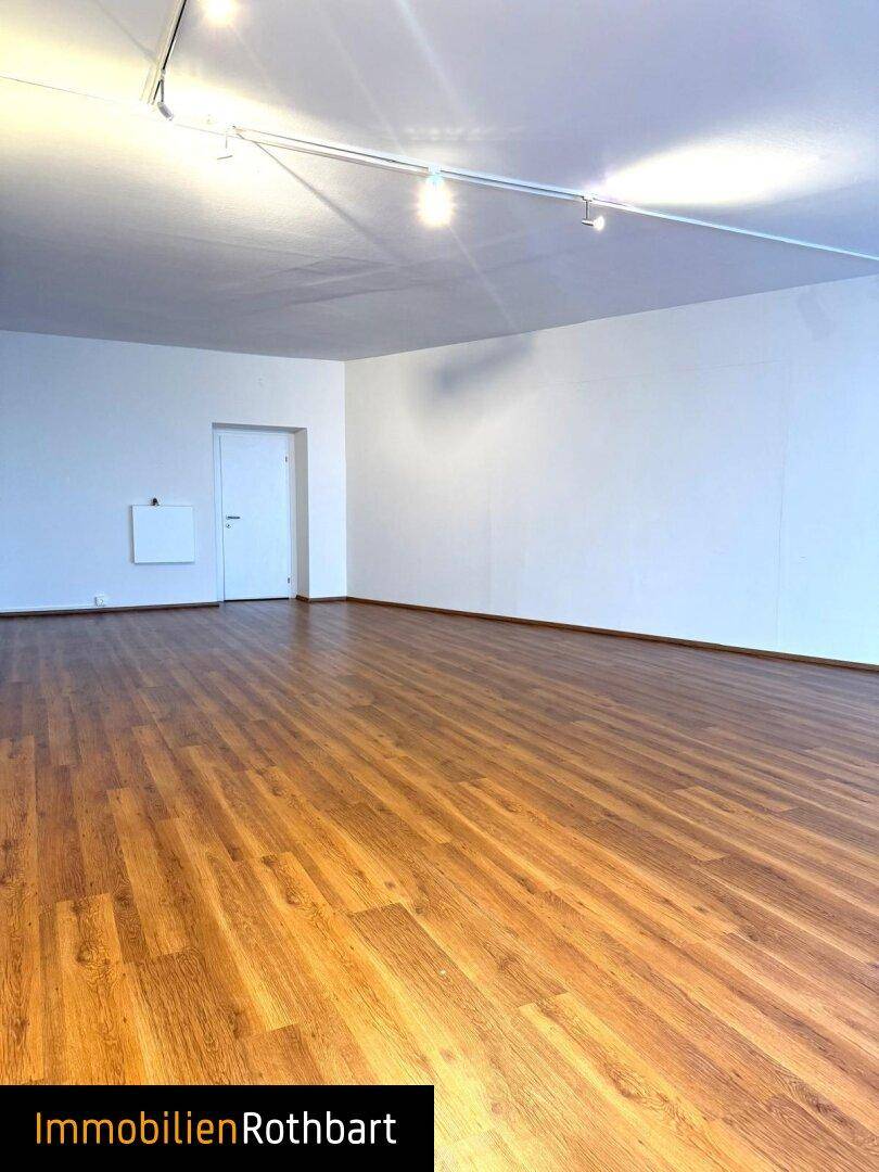 Heller, leerer Raum mit modernem Laminatboden und schlichter Gestaltung, bereit zur individuellen Einrichtung.