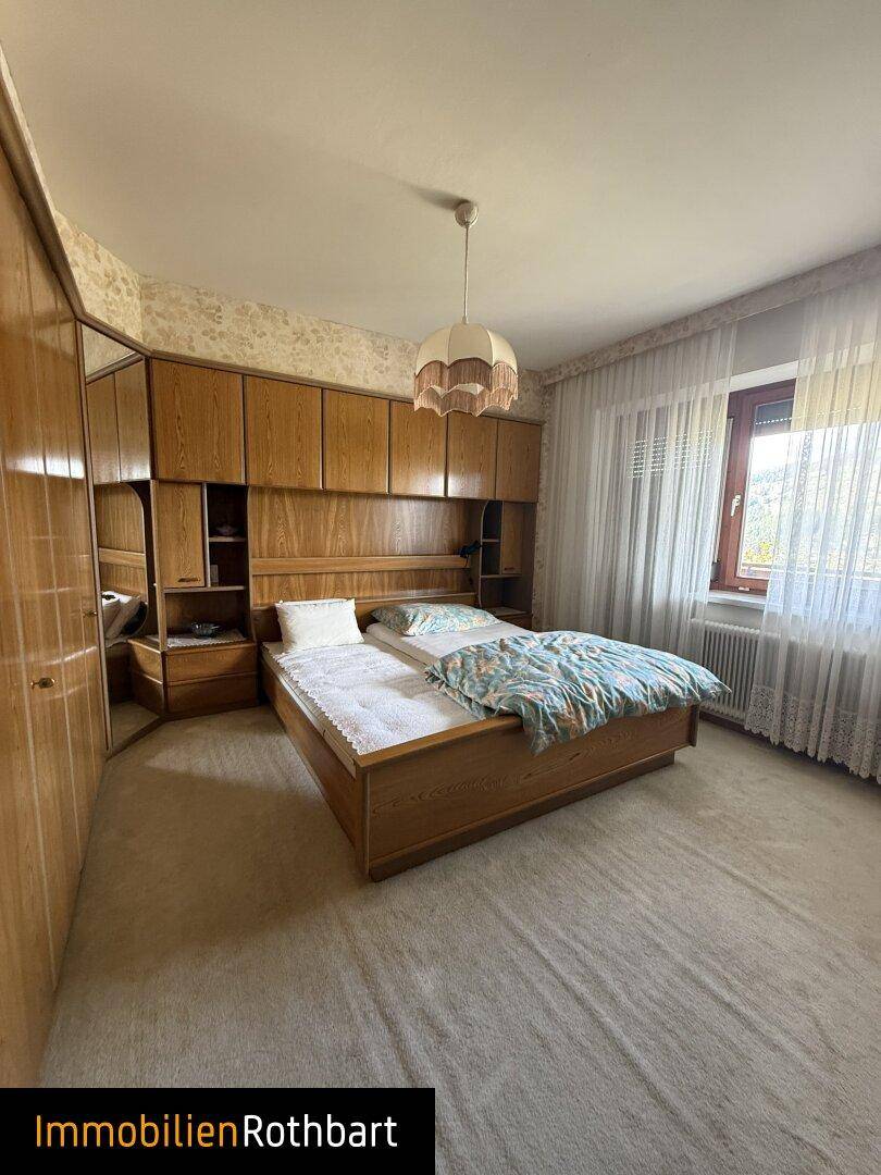 Schlafzimmer mit Doppelbett, Einbauschränken und Teppichboden.