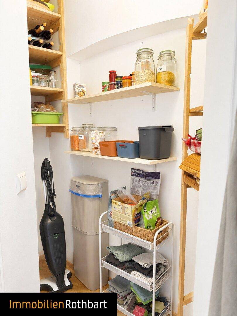 Gut organisierte Speisekammer mit Regalen voller Vorräte und Haushaltsgeräten.