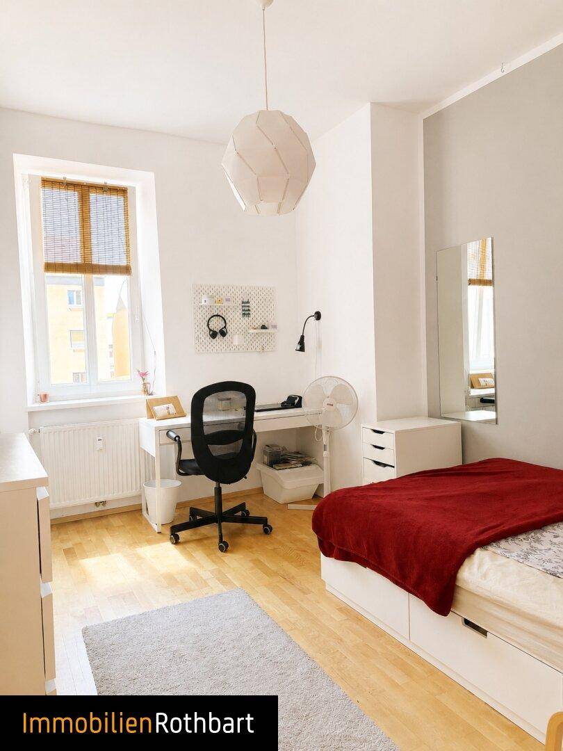 Helles Schlafzimmer mit Einzelbett, Schreibtisch und Holzfußboden, ideal für Kinder oder Gäste.