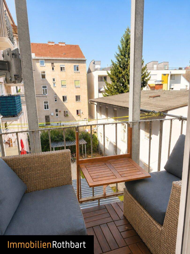 Gemütlicher Balkon mit Sitzgelegenheiten und einem kleinen Tisch, mit Blick auf die Umgebung.