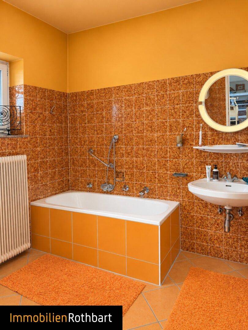 Badezimmer mit Badewanne, Waschbecken und orangefarbenen Fliesen, hell und funktional.