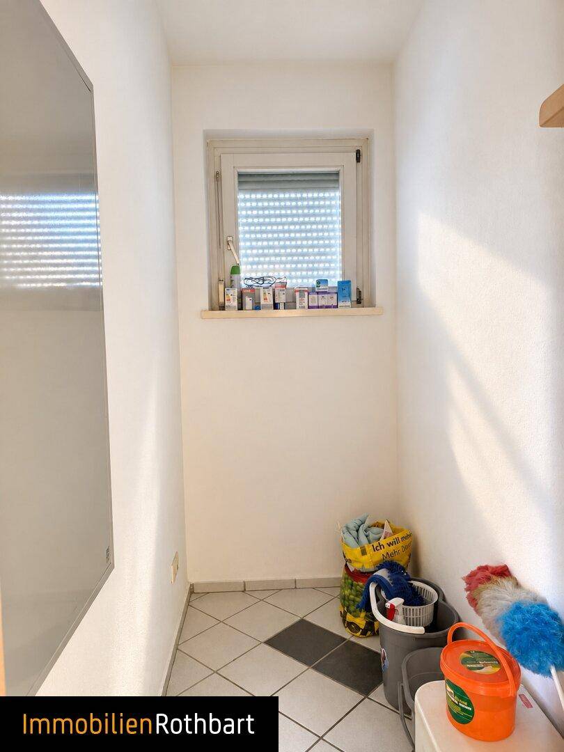 Kleiner Hauswirtschaftsraum mit Fenster, Fliesenboden und Stauraum.