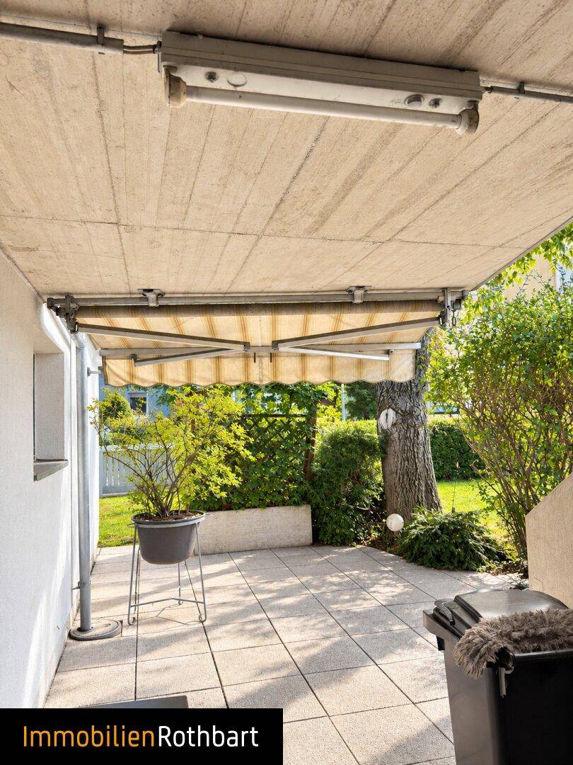 Gemütliche Terrasse mit ausfahrbarer Markise und Zugang zum Gartenbereich.