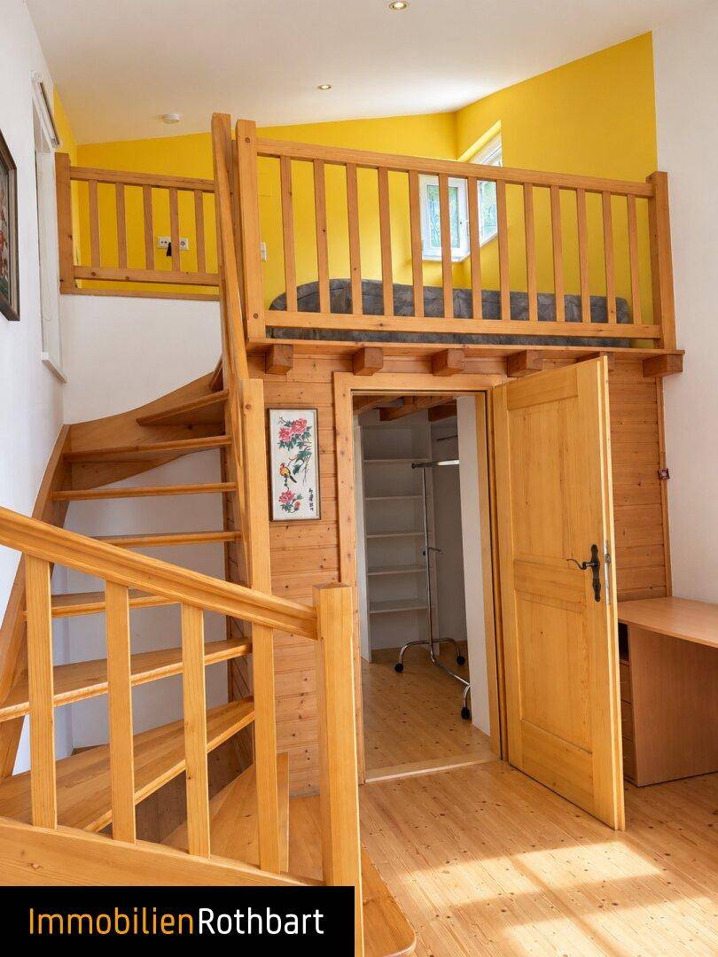 Schlafzimmer mit Holztreppe zu einem Hochbett und gelben Akzentwänden.