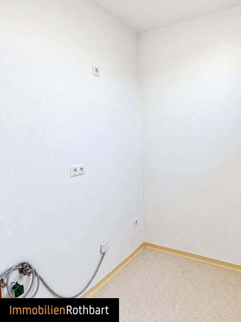 Kleiner Raum mit Anschlüssen für Waschmaschine oder Spüle und hellem Boden.