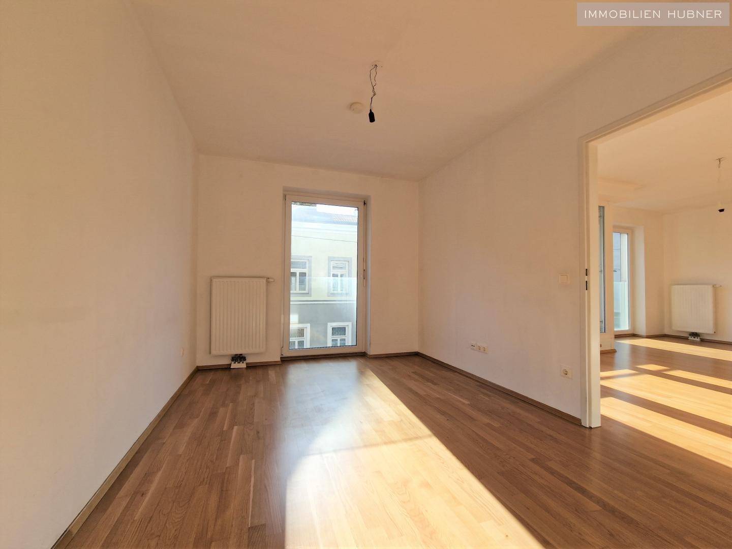 Geräumiges Zimmer mit Parkettboden und viel Tageslicht, ideal als Schlafzimmer.