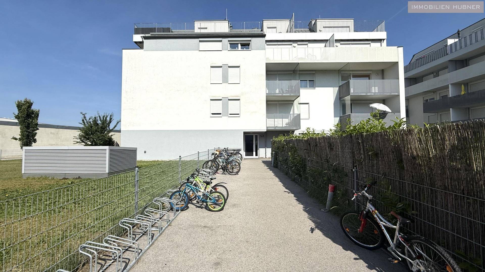 Moderne Wohnanlage mit Fahrradabstellplätzen und gepflegter Außenanlage.
