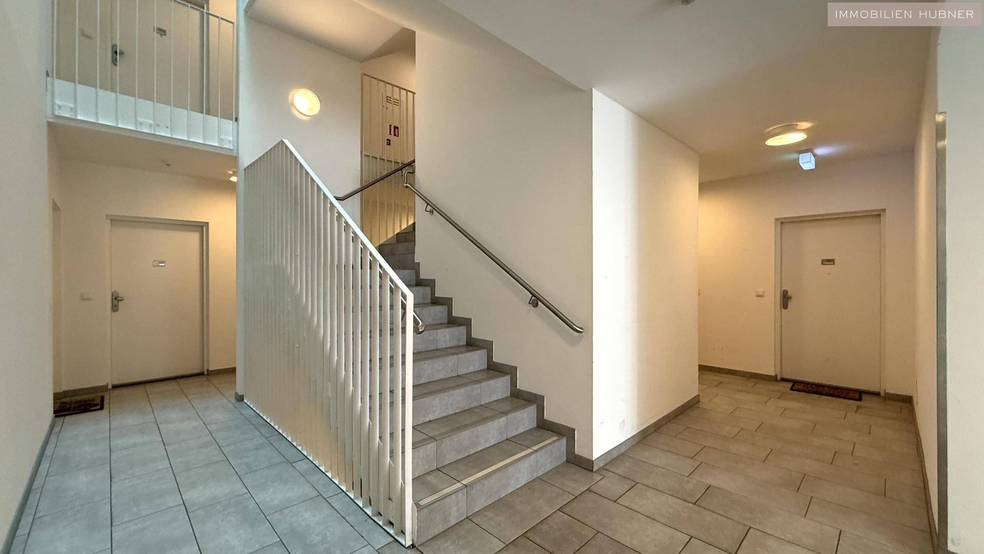Treppenhaus und Flur im modernen Wohngebäude mit Zugang zu den Wohnungen.