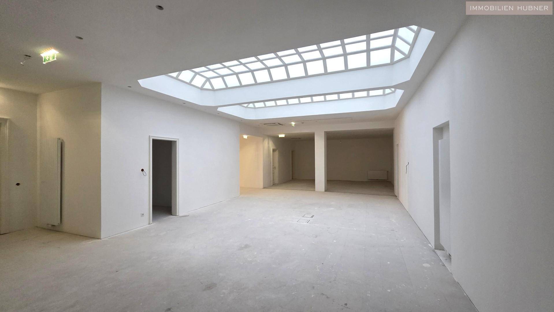 Großer, heller Raum mit beeindruckendem Oberlicht, ideal für flexible Nutzung.