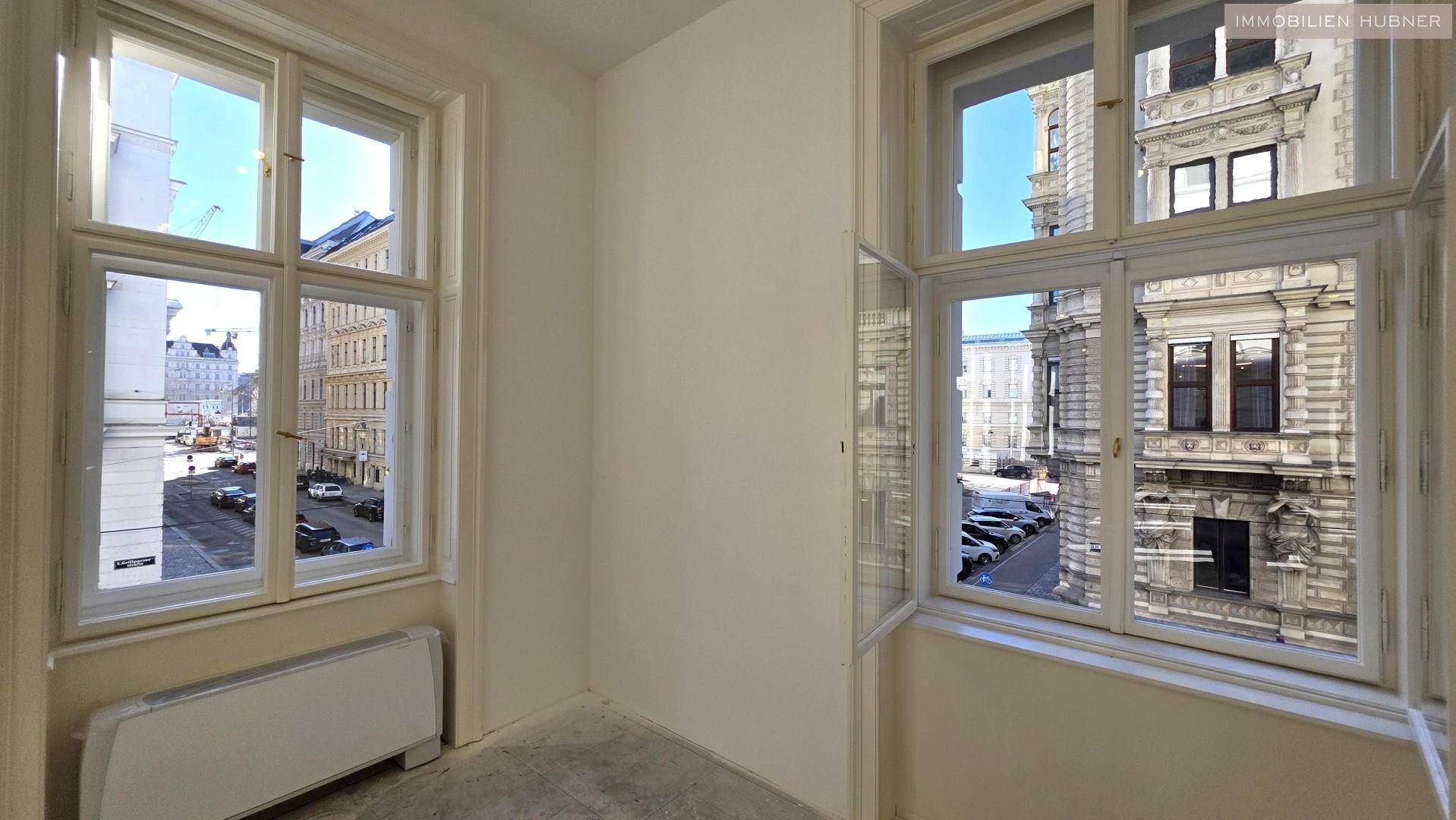 Fenster mit Blick auf die historische Stadtarchitektur und die belebte Straße, die viel Tageslicht hereinlassen und eine schöne Aussicht bieten.