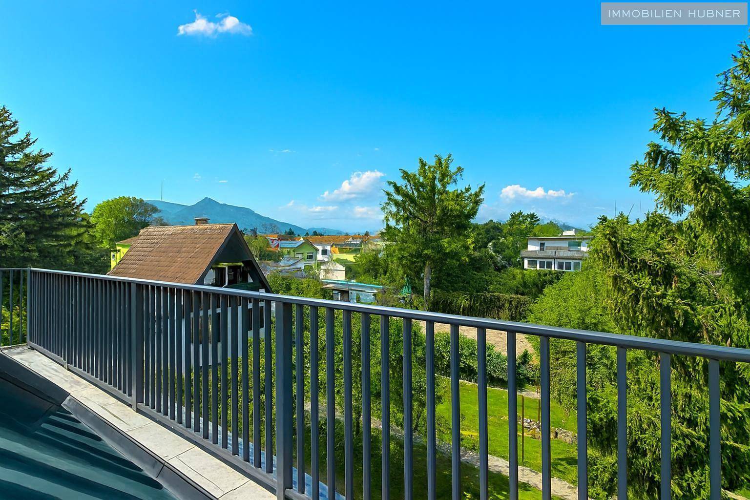 Sonniger Terrassenbereich mit weitem Blick auf die Berge und die grüne Landschaft.