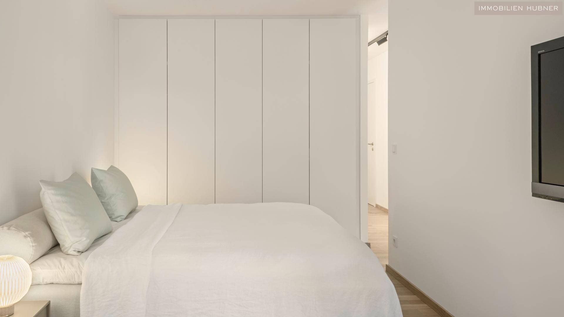 Gemütliches Schlafzimmer mit Einbauschränken und modernem Bett, ideal für Stauraum.