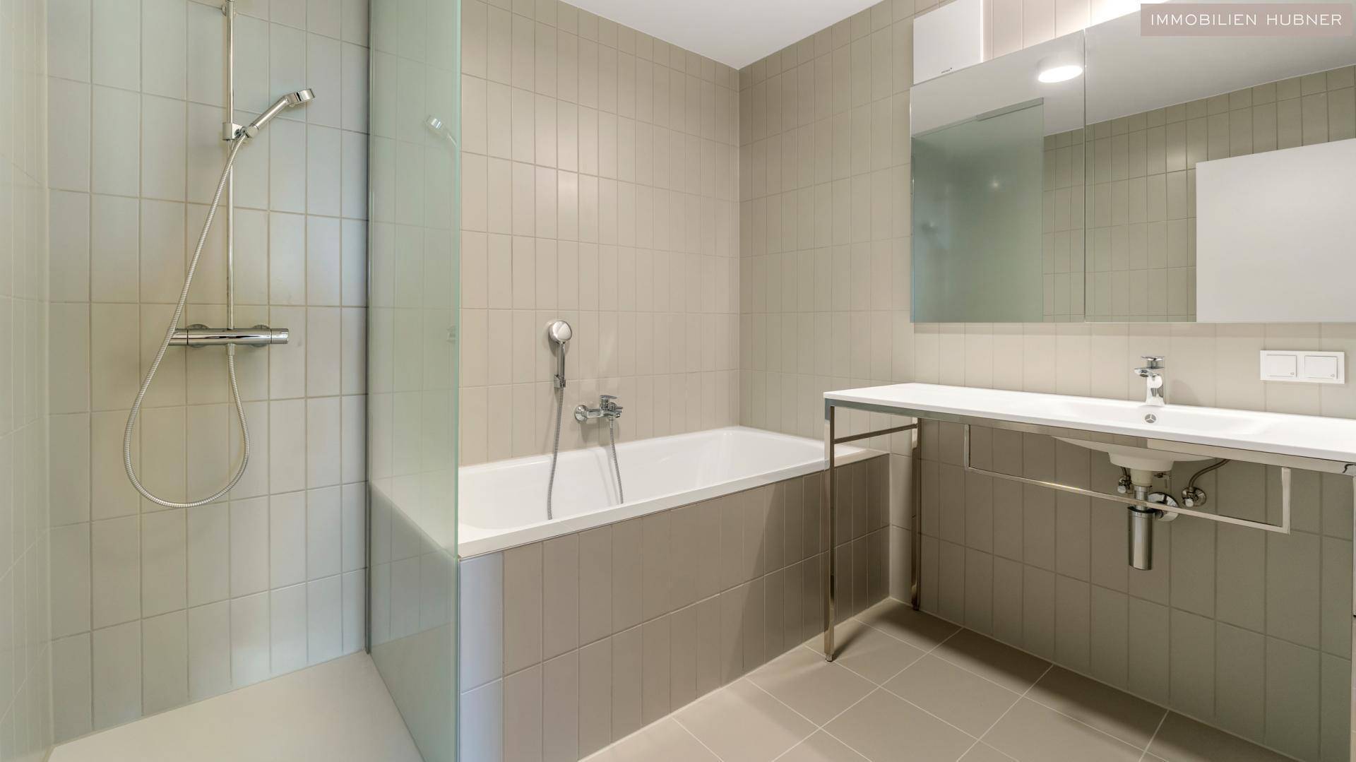 Helles Badezimmer mit Badewanne, separater Dusche und modernem Einzelwaschbecken.