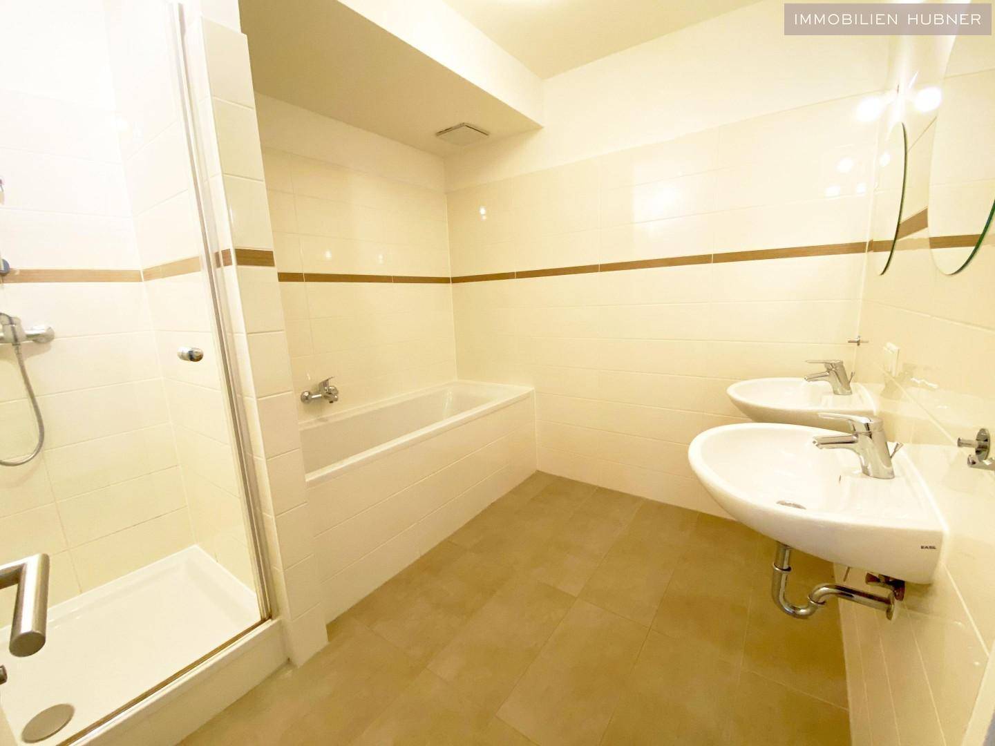 Modernes Badezimmer mit Dusche, Badewanne und Doppelwaschbecken.