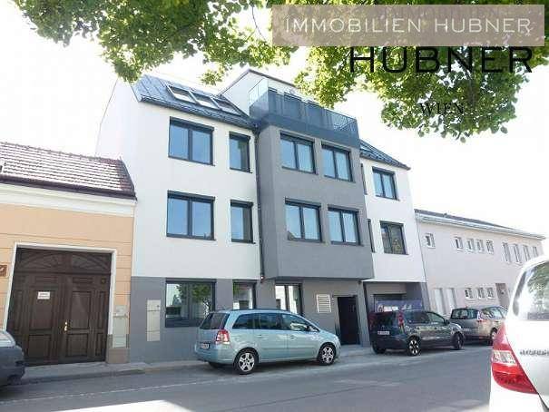 Moderne Gebäudefassade mit großen Fenstern und Balkonen an einer städtischen Straße.