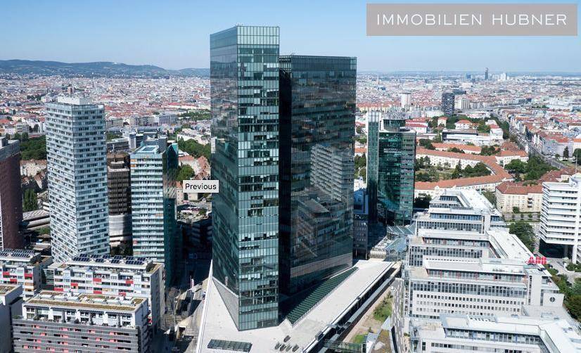 Beeindruckendes modernes Hochhaus mit Glasfassade, umgeben von städtischer Architektur und Weitblick.