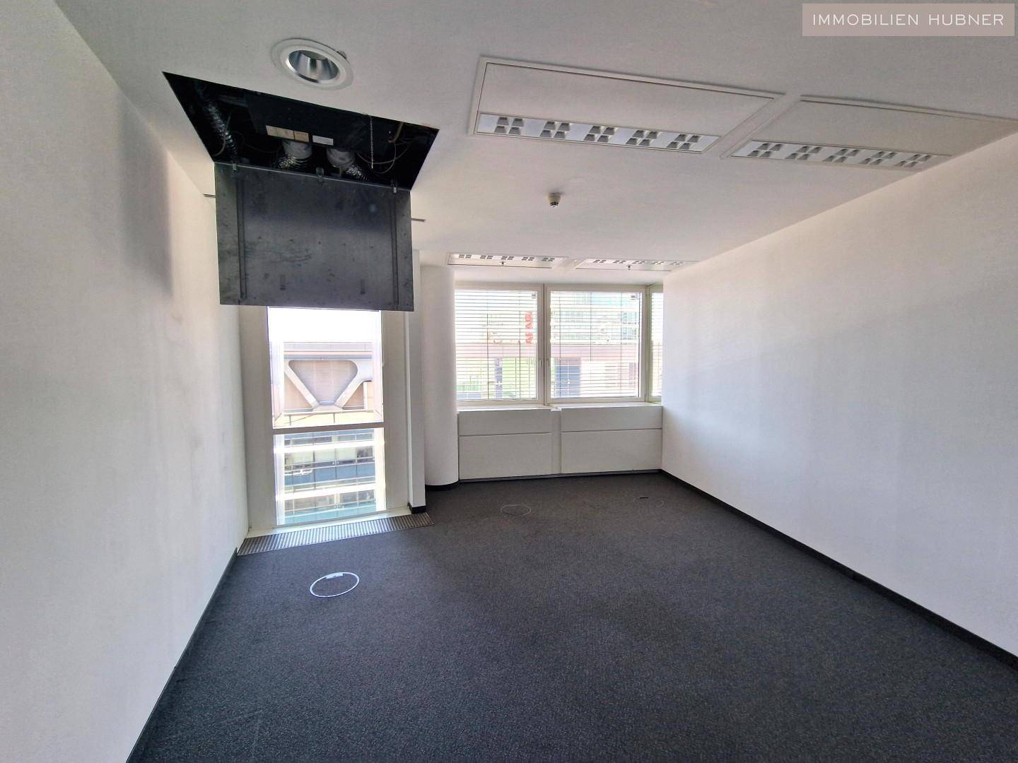 Kleinerer Büroraum mit Teppichboden und Fenster, ideal für ein Einzelbüro oder Besprechungszimmer.