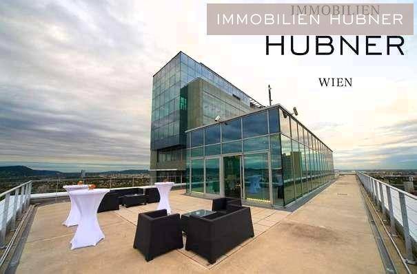 Exklusive Dachterrasse mit moderner Glasstruktur, Sitzgelegenheiten und weitem Blick über die Stadtlandschaft.