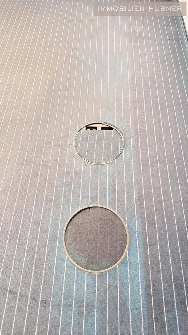 Detailaufnahme des gestreiften Teppichbodens mit integrierten Bodentank-Anschlüssen.
