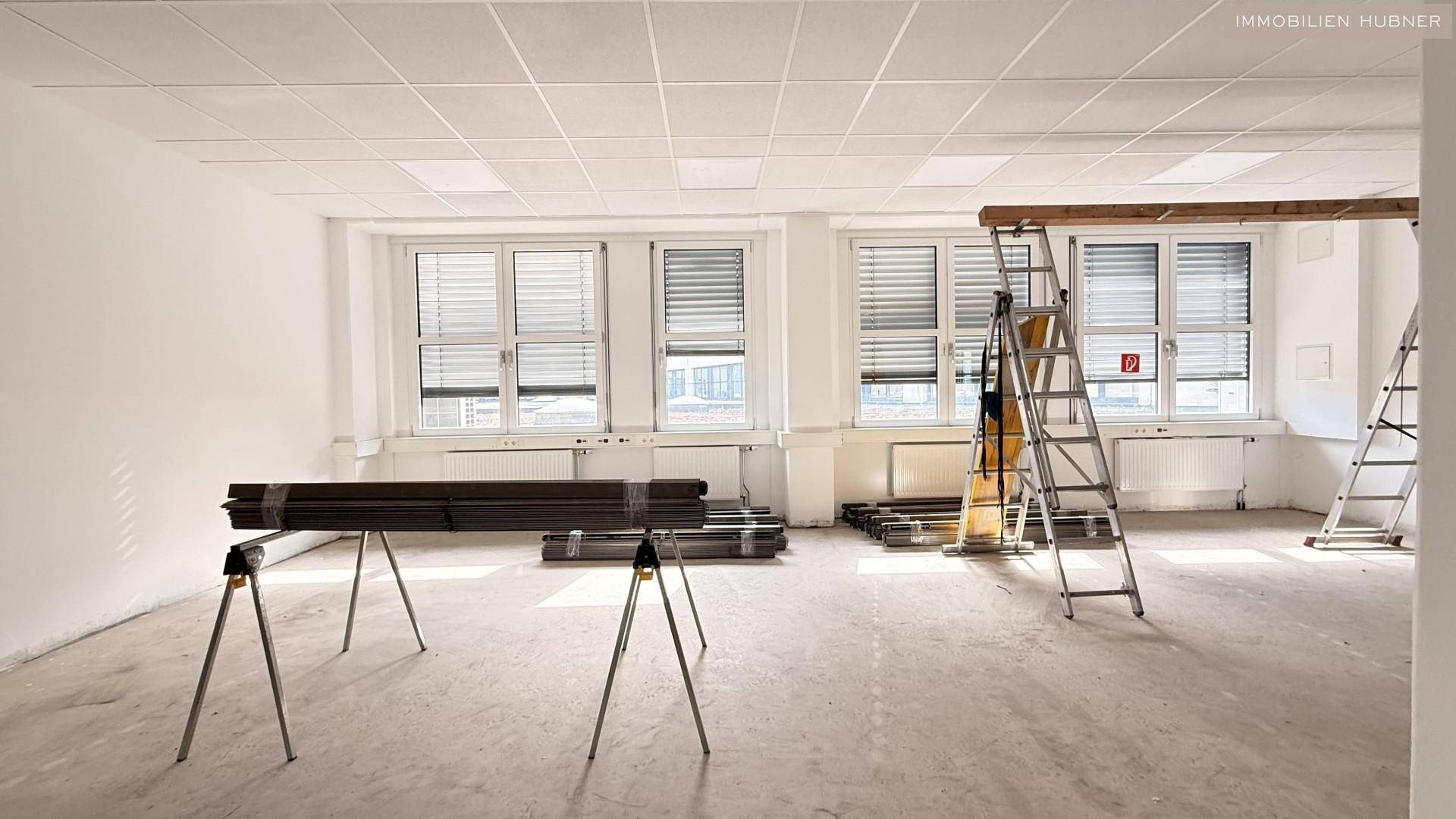 Bürofläche in Renovierung mit Baumaterialien und Leitern, bietet viel Potenzial zur Gestaltung.