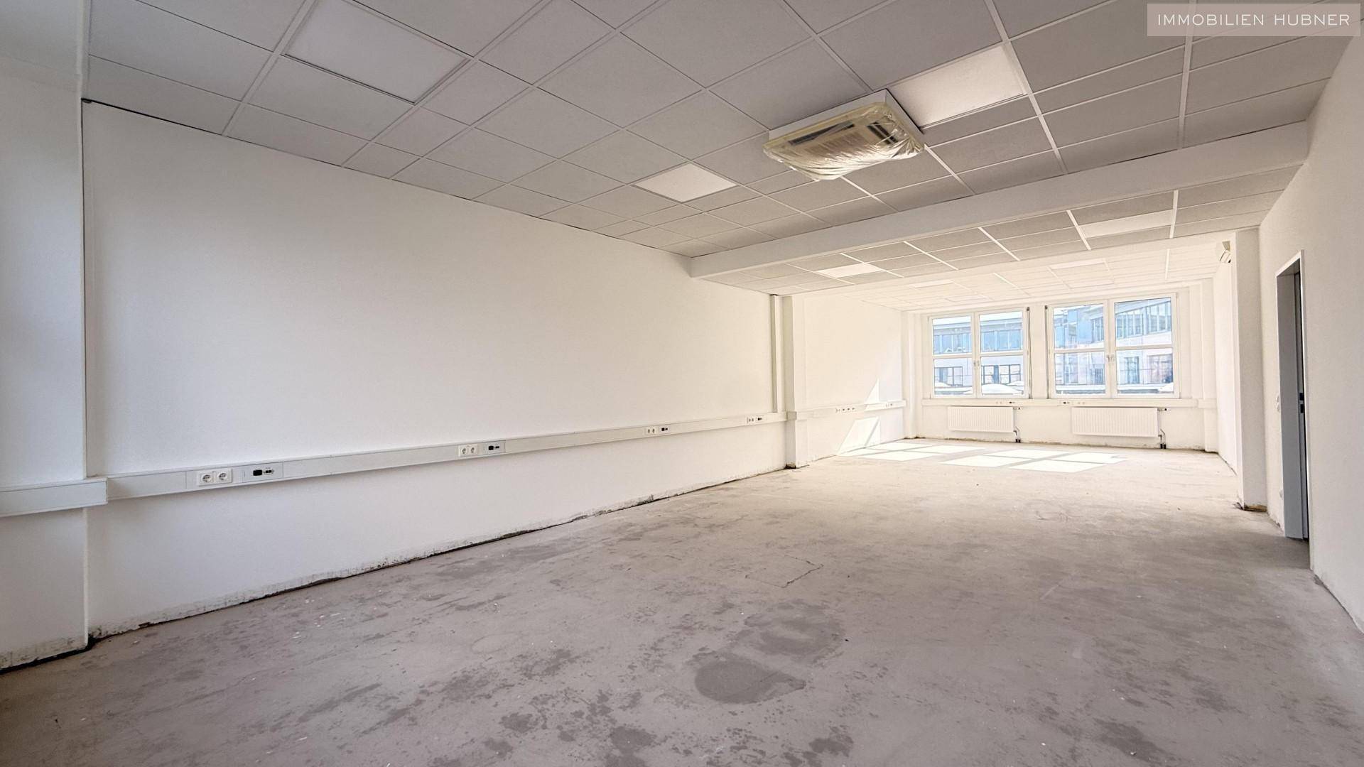 Geräumiges, leeres Büro mit vielen Steckdosen und Klimaanlage, bereit für neue Mieter.