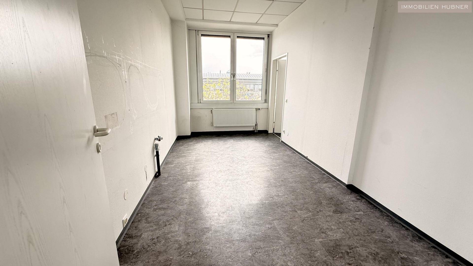 Kleiner Raum mit dunklem Vinylboden und Fenster, vorbereitet für weitere Installationen.