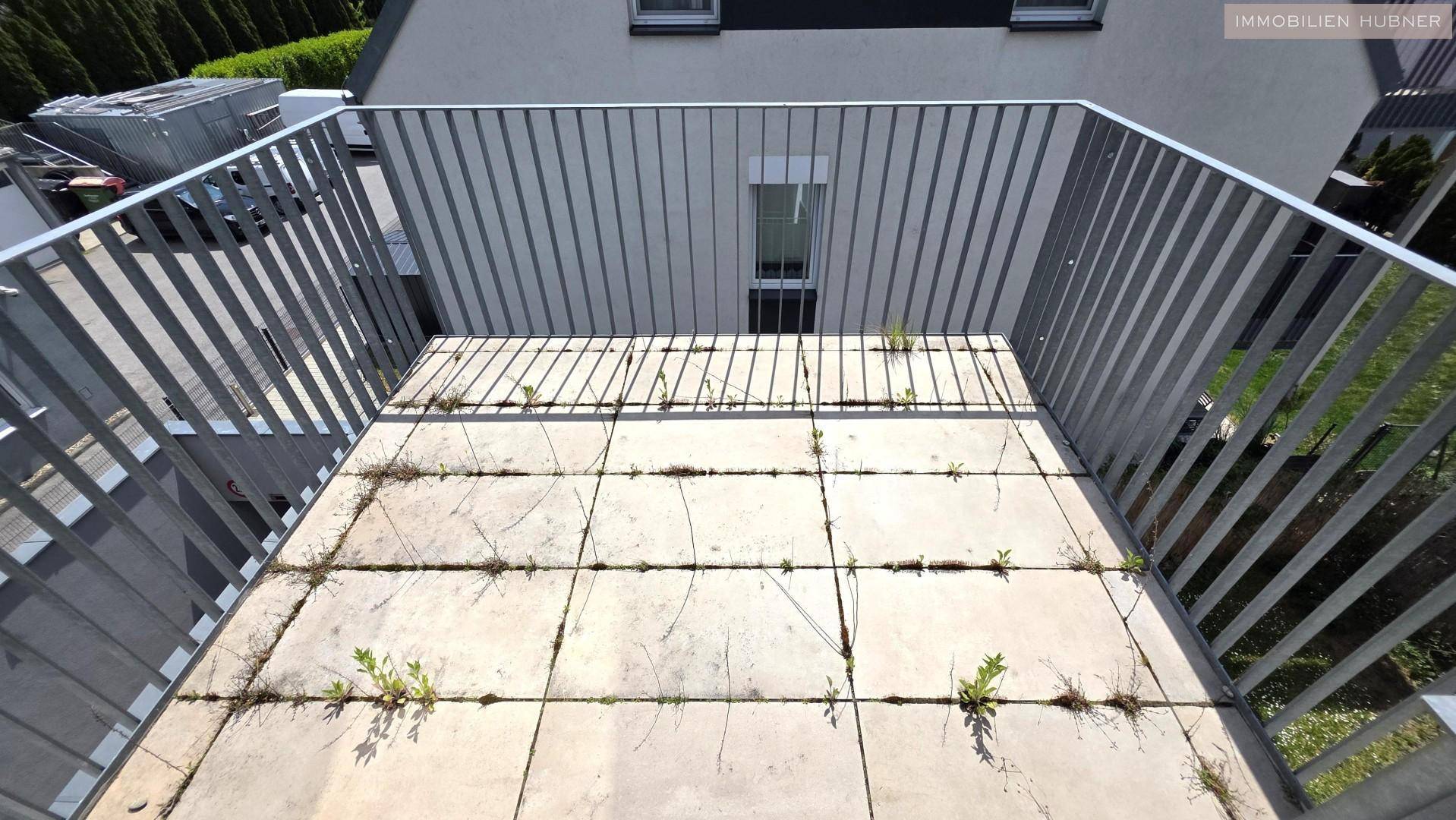 Balkon mit Fliesenboden und Metallgeländer, bereit für individuelle Gestaltung.