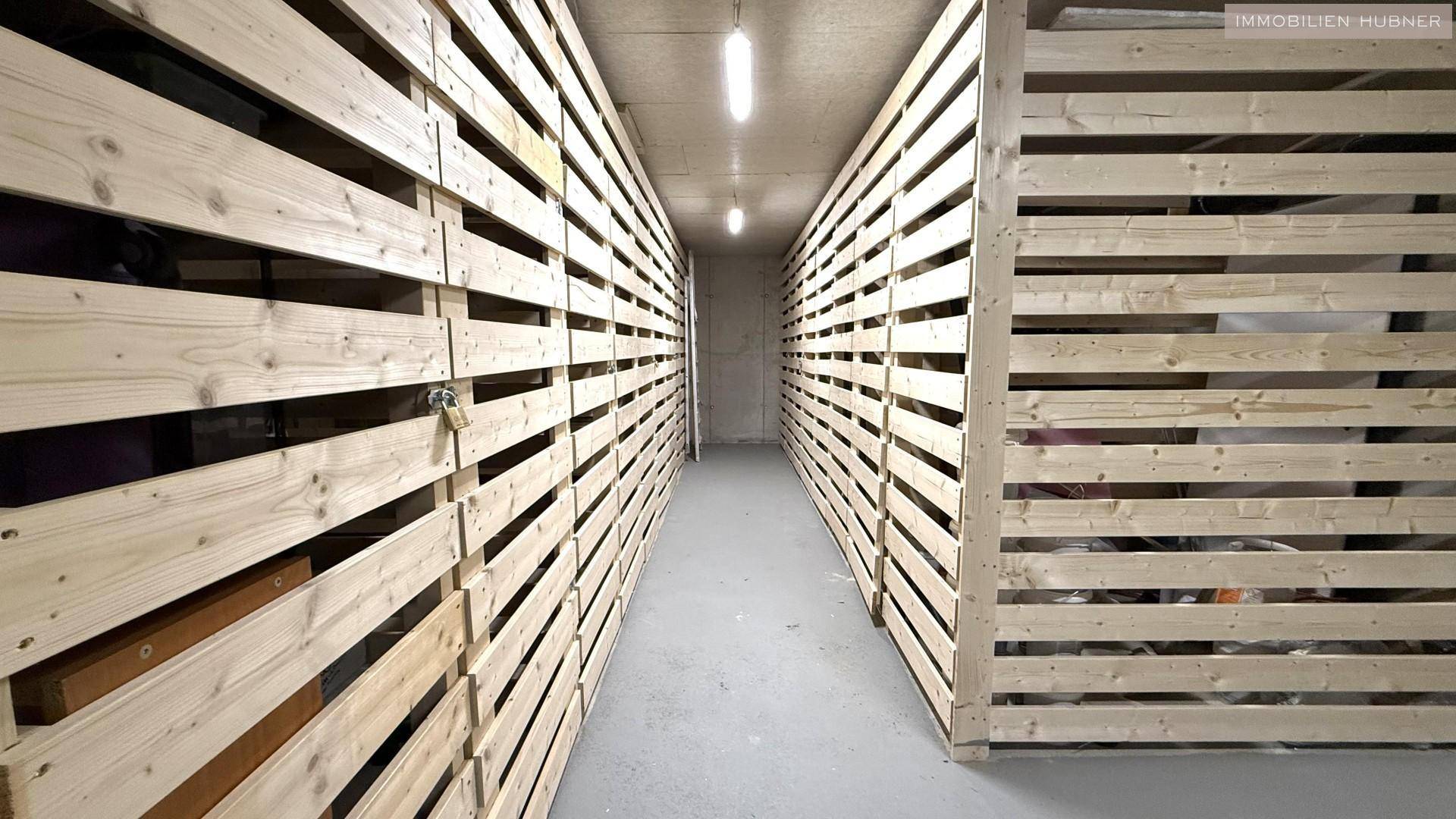 Reihen von individuellen Kellerabteilen aus Holzlatten für zusätzlichen Stauraum, gut organisiert.
