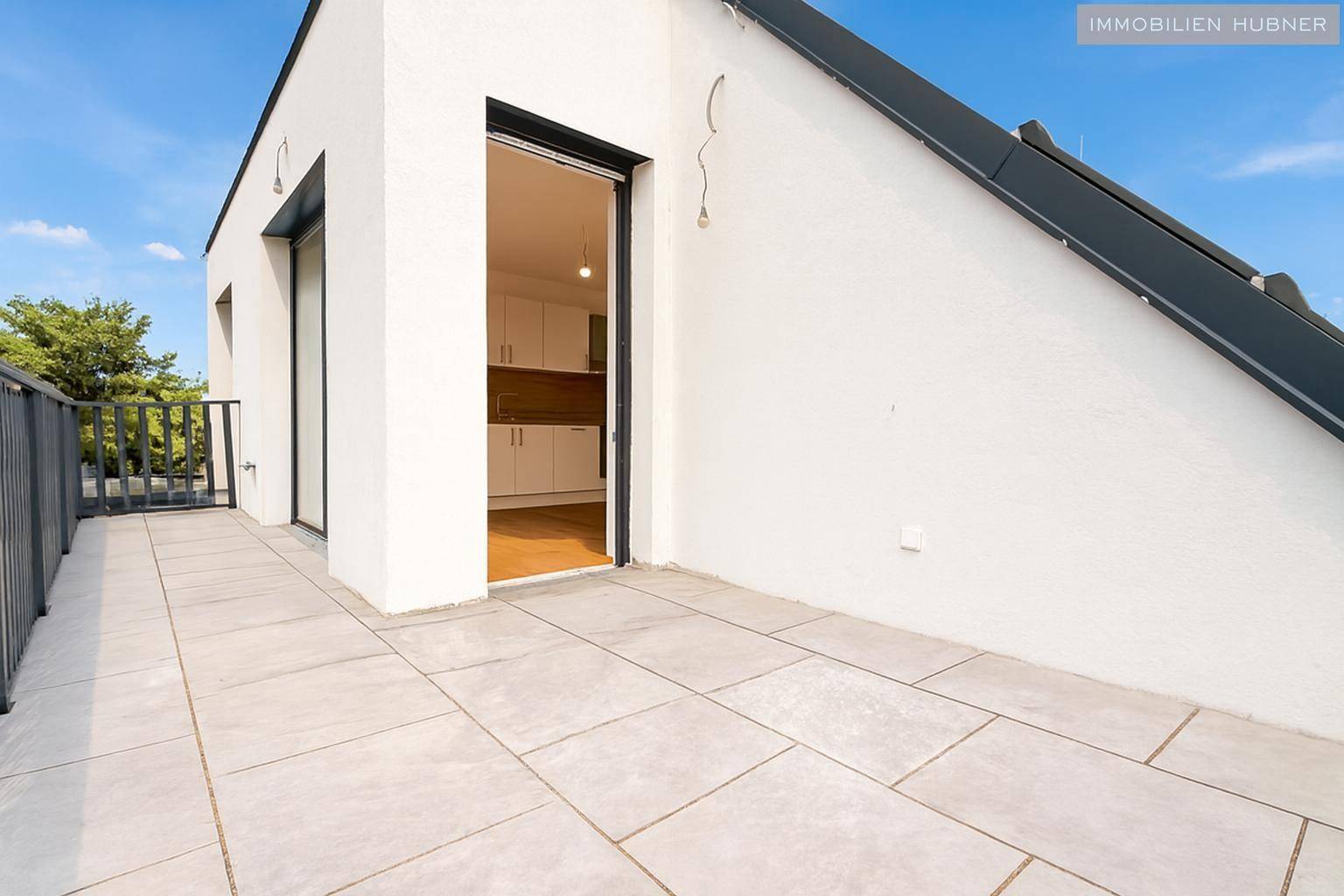 Moderne Dachterrasse mit Fliesenboden und direktem Zugang zum Innenbereich der Wohnung, sehr praktisch.