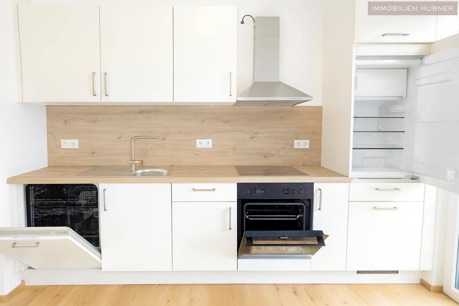 Voll ausgestattete Küche mit Geschirrspüler, Backofen und Kühlschrank.