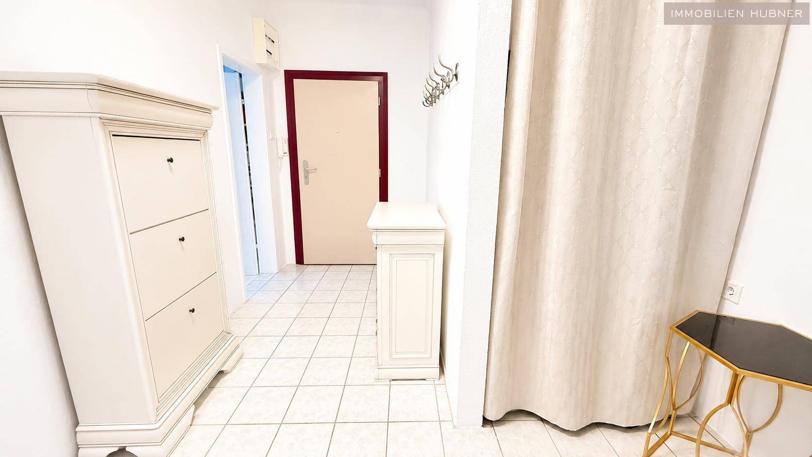 Geräumiger Flur mit weißem Schuhschrank und Garderobe, bietet viel Stauraum.