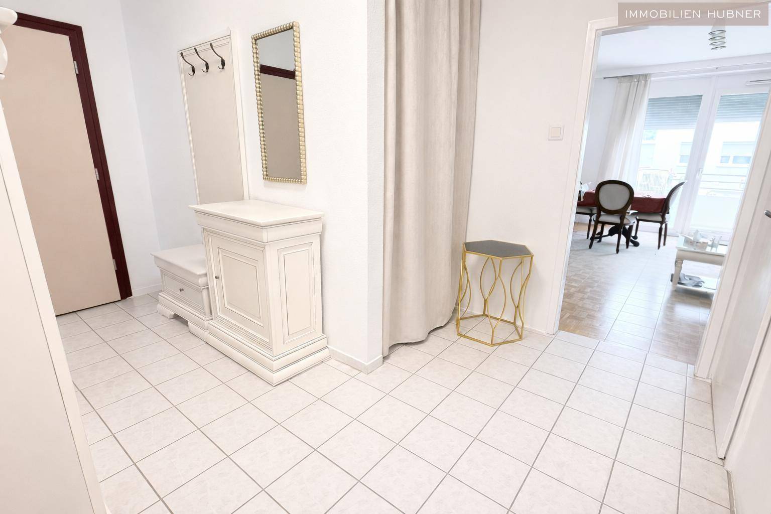 Heller Eingangsbereich mit Fliesenboden, Garderobe und Zugang zum Wohnbereich.