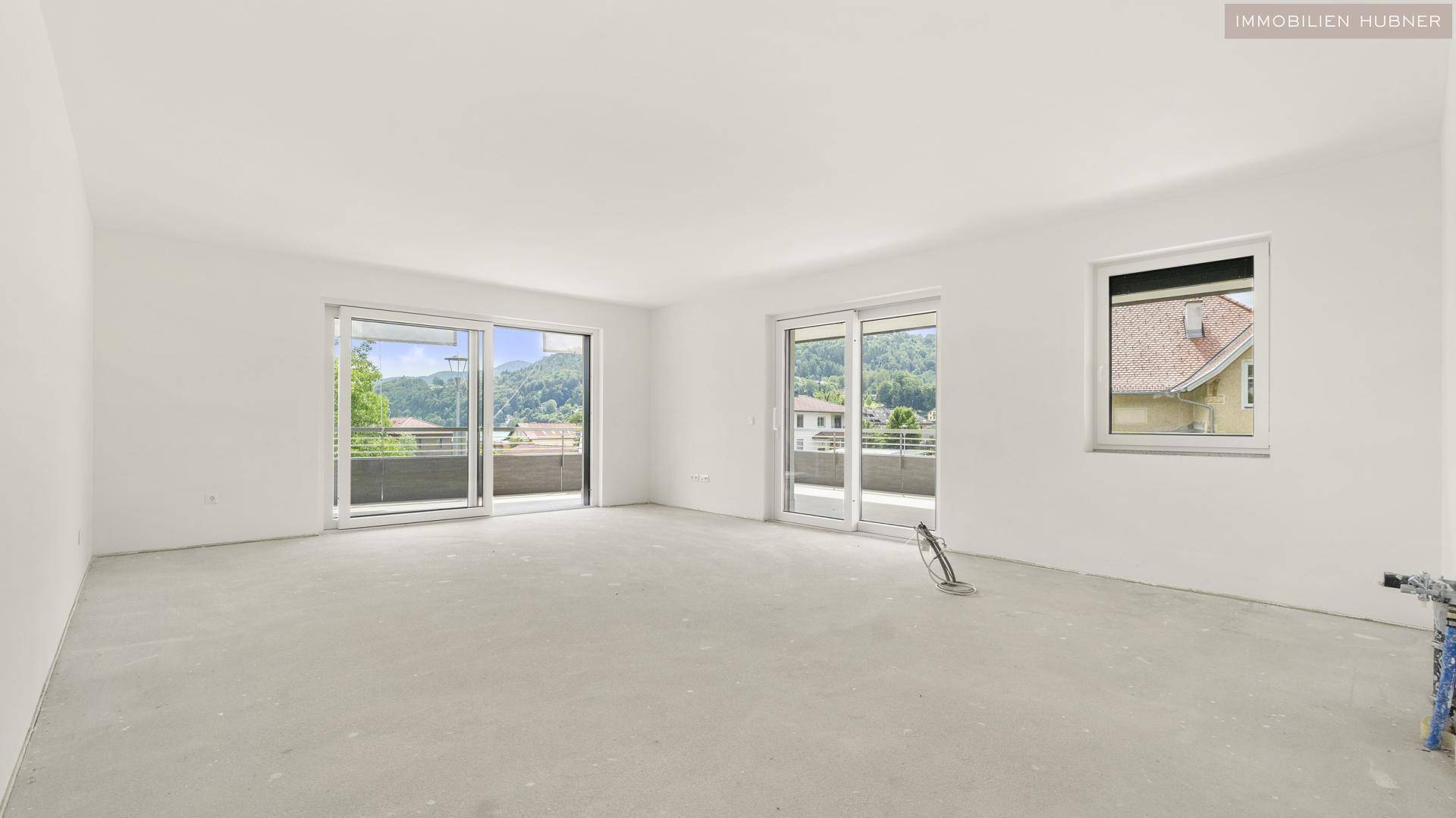 Heller, unmöblierter Wohnbereich mit großen Schiebetüren, die Zugang zu einem Balkon bieten.