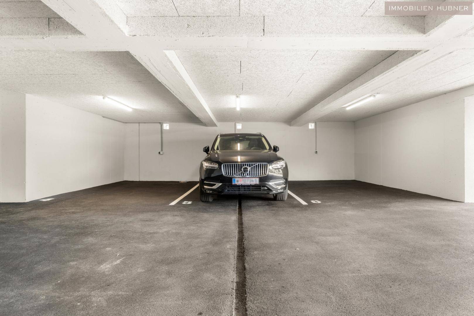 Saubere Tiefgarage mit einem geparkten Auto und ausreichend Platz für weitere Fahrzeuge.