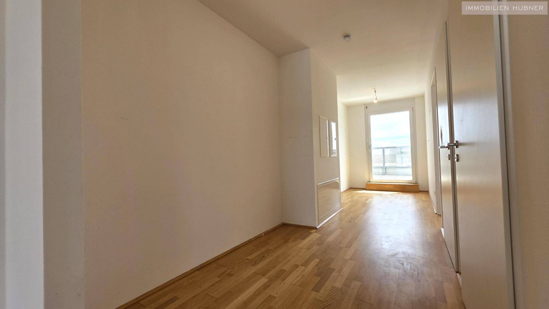 Heller Flur mit Parkettboden, der zu den verschiedenen Räumen der Wohnung führt.