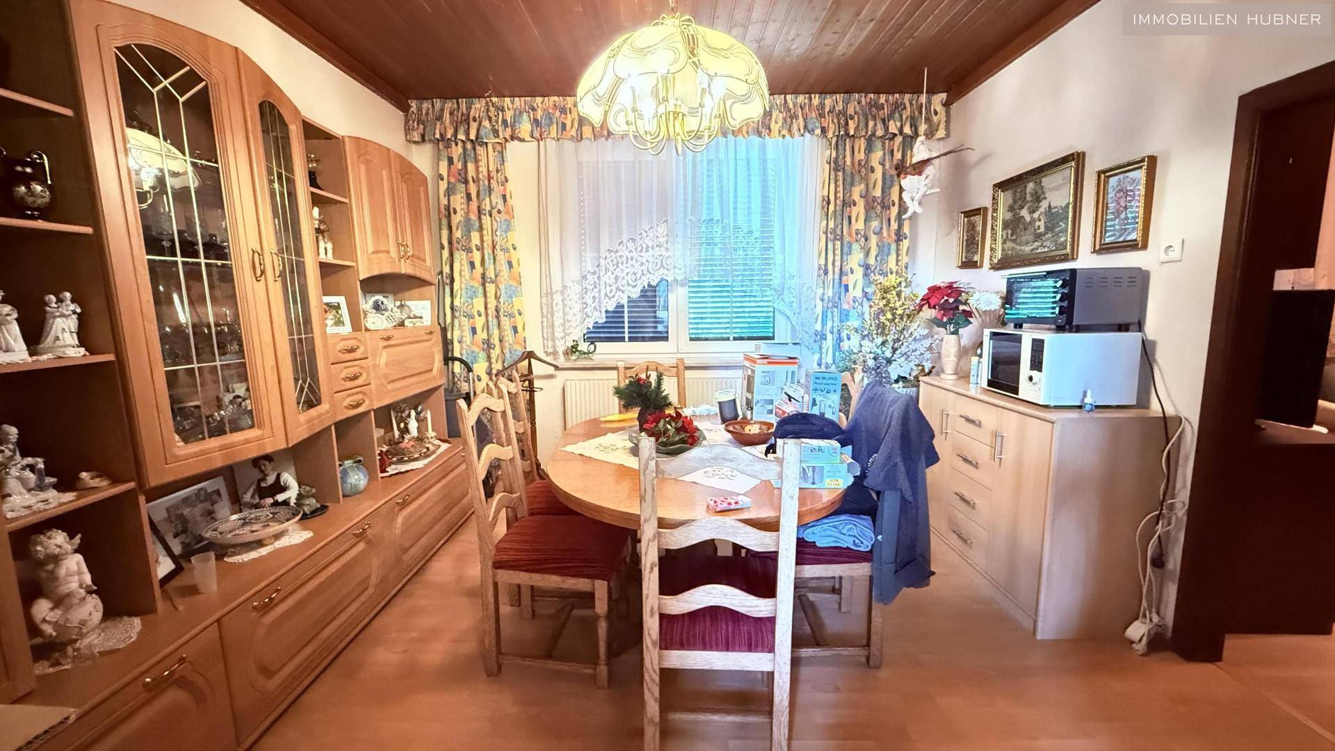 Klassischer Essbereich mit Holztisch, Stühlen und passenden Vitrinenschränken.