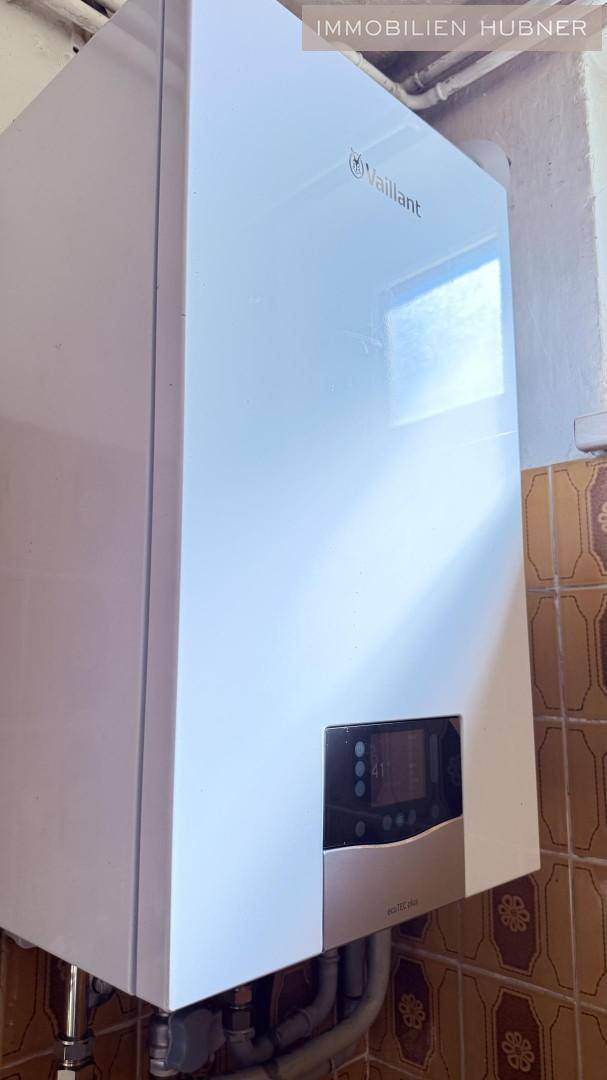 Heizungsraum mit einer modernen Vaillant Gastherme und gefliesten Wänden.