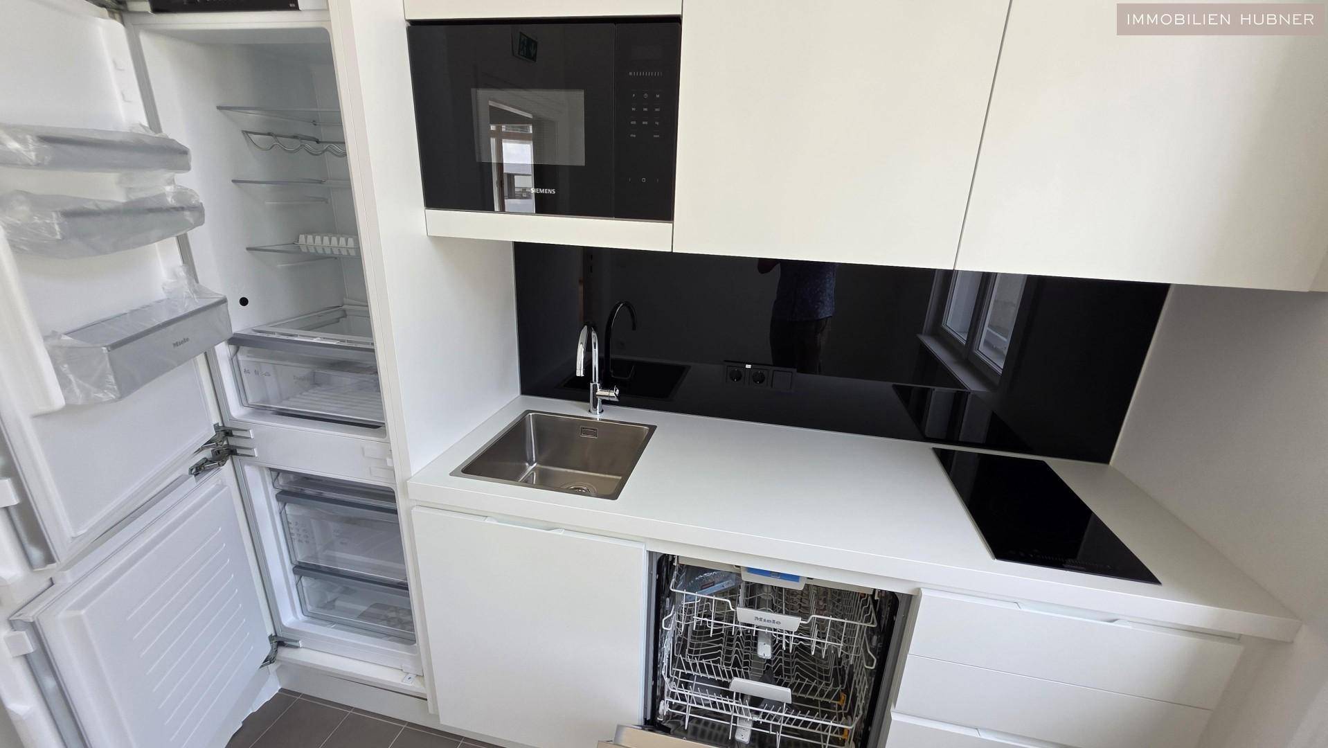 Detailansicht der modernen Küchenzeile mit integriertem Kühlschrank, Geschirrspüler und Induktionskochfeld.
