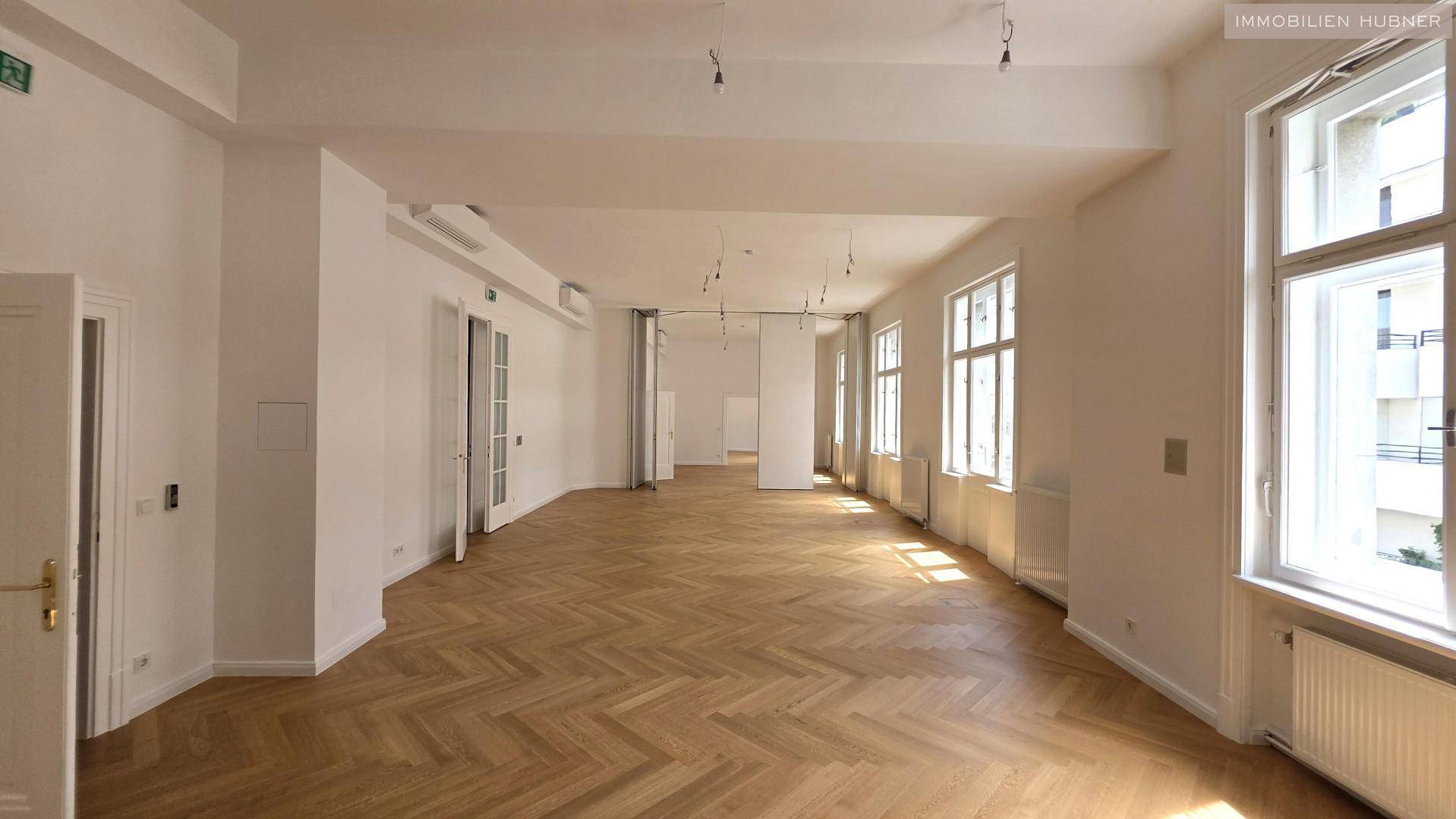 Großer, heller Büroraum mit Fischgrätparkett und hohen Decken, bereit zur individuellen Gestaltung.