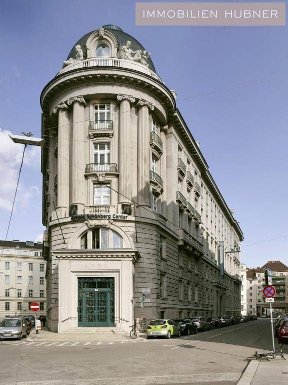 Beeindruckende historische Fassade eines Eckgebäudes mit klassischer Architektur und großen Fenstern.