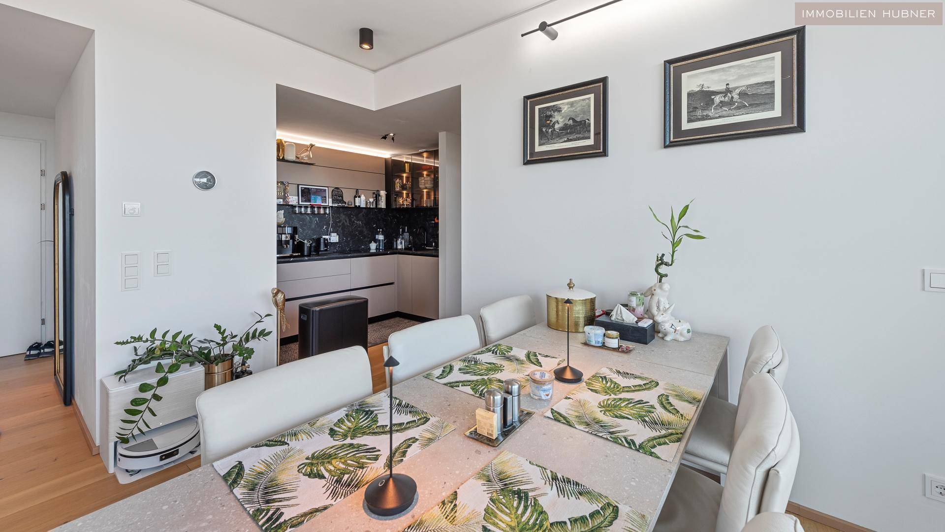 Eleganter Essbereich mit gedecktem Tisch und Blick auf eine moderne, offene Küche.
